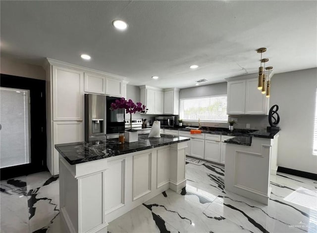 kitchen featuring white cabinets, stainless steel fridge, a kitchen island, and hanging light fixtures