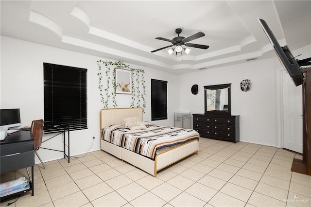 tiled bedroom featuring a raised ceiling and ceiling fan