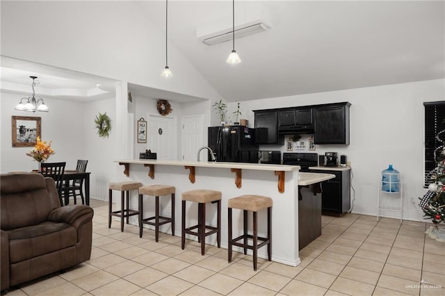 kitchen featuring a kitchen bar, black appliances, decorative light fixtures, and a notable chandelier