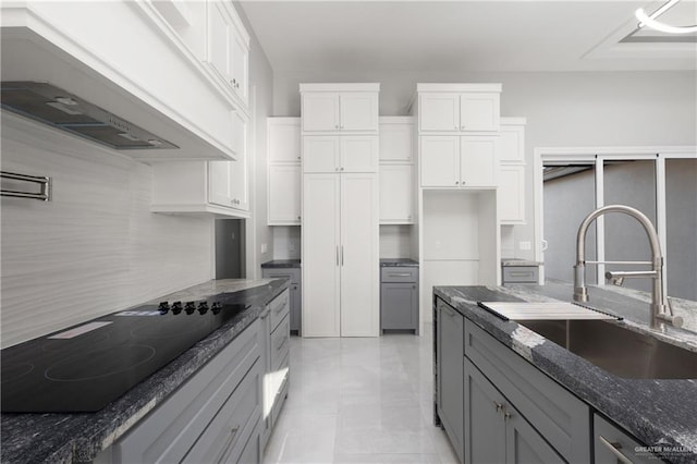 528 Candela St, Edinburg, TX 78542 - kitchen featuring black electric cooktop, gray cabinetry, premium range hood, a sink, and dark stone countertops