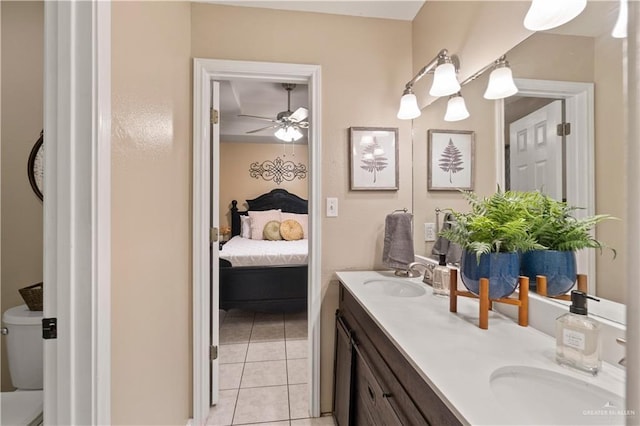 1602 Meadow Ln, Harlingen, TX 78550 - bathroom featuring connected bathroom, toilet, tile patterned floors, double vanity, and ceiling fan