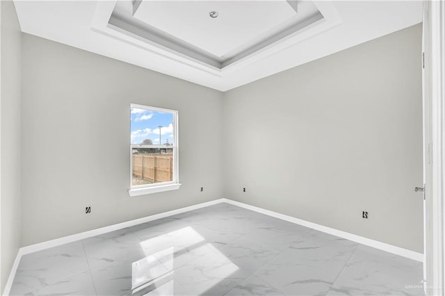 unfurnished room featuring a tray ceiling