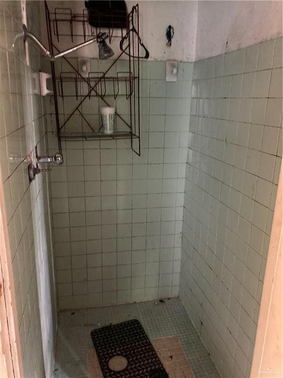 bathroom with tile patterned floors and tiled shower