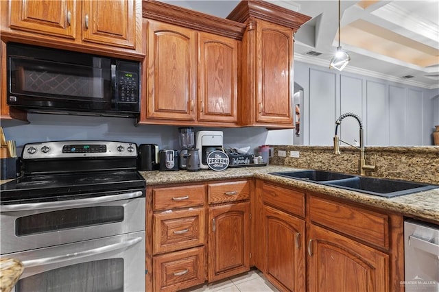 kitchen with light stone countertops, brown cabinetry, appliances with stainless steel finishes, light tile patterned flooring, and a sink