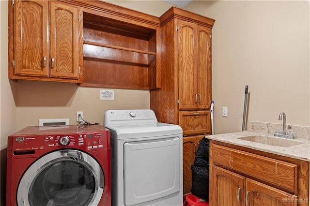 clothes washing area featuring a sink, cabinet space, and separate washer and dryer