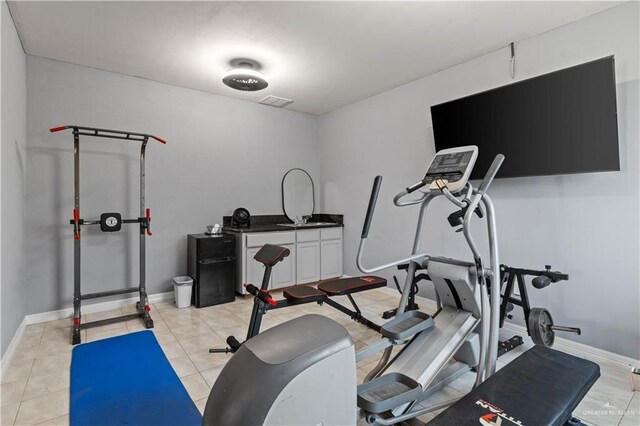 workout room with light tile patterned floors, baseboards, and visible vents