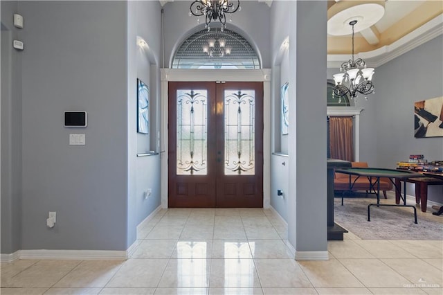 entrance foyer featuring french doors, a high ceiling, an inviting chandelier, and light tile patterned floors
