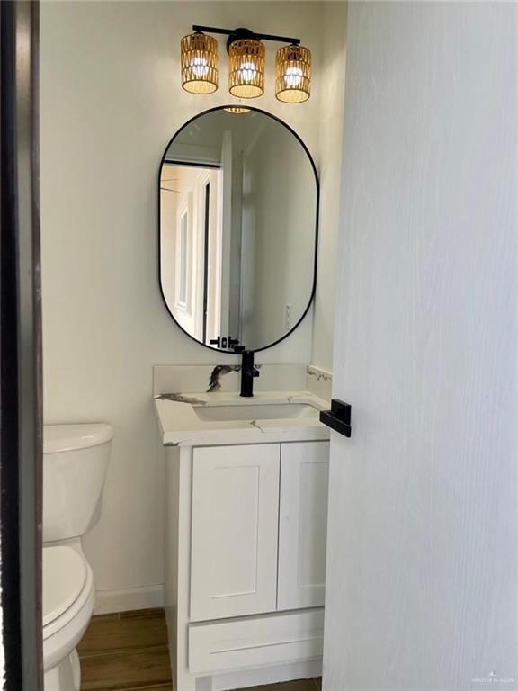 bathroom featuring hardwood / wood-style floors, vanity, and toilet