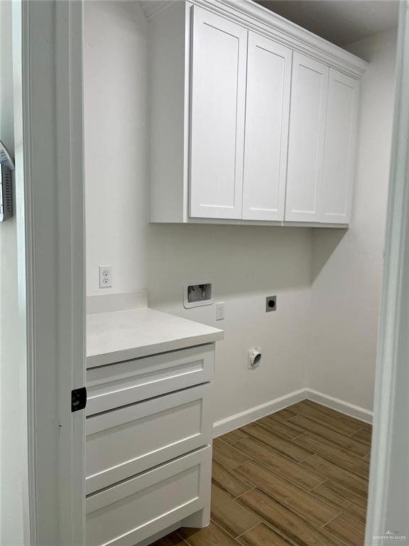 washroom with cabinets, hookup for a washing machine, electric dryer hookup, and dark wood-type flooring