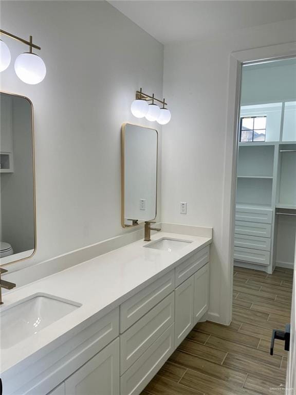 bathroom with toilet, vanity, and hardwood / wood-style flooring