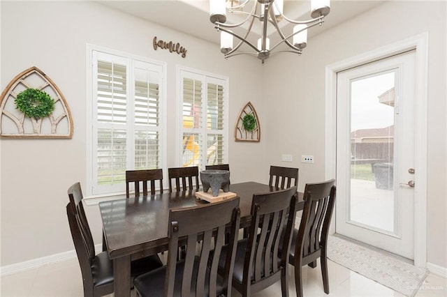 dining room with a chandelier, light tile patterned floors, and a healthy amount of sunlight