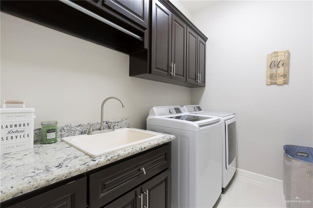 washroom with washing machine and clothes dryer, sink, and cabinets