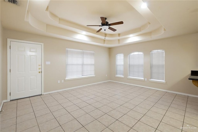 spare room featuring ceiling fan and a raised ceiling