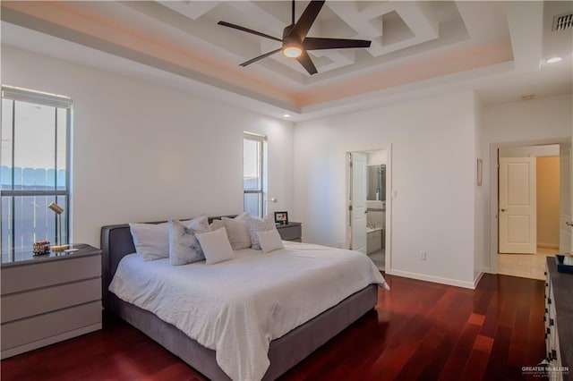 bedroom with ceiling fan, ensuite bathroom, dark wood-type flooring, and a tray ceiling