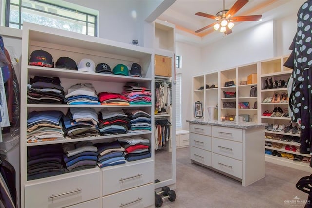 walk in closet featuring a towering ceiling and ceiling fan