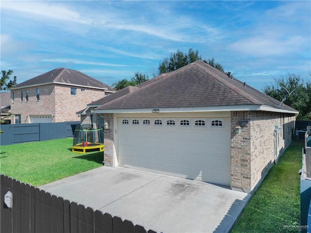 view of side of home featuring a lawn, an outbuilding, and a garage