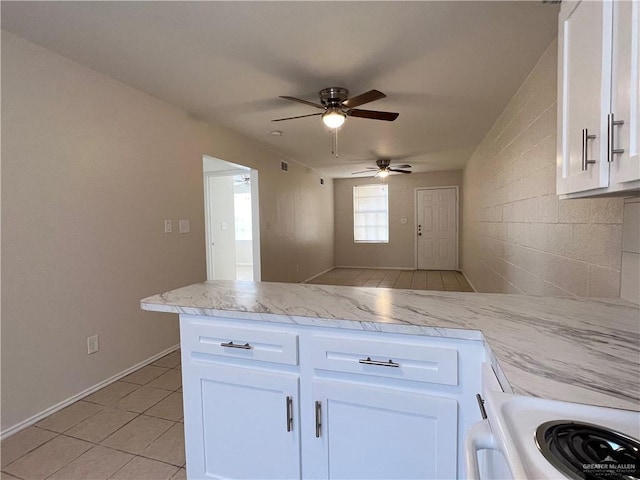225 N 28th St, Mcallen, TX 78501 - kitchen featuring a peninsula, a ceiling fan, white cabinetry, light tile patterned flooring, and electric range