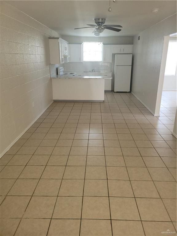 225 N 28th St, Mcallen, TX 78501 - kitchen with freestanding refrigerator, a ceiling fan, a peninsula, and white cabinets