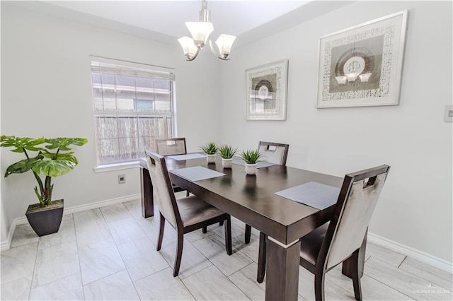 dining room featuring baseboards and a notable chandelier