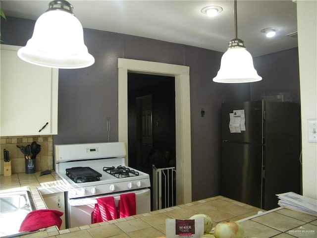 501 W Lovett St, Edinburg, TX 78541 - kitchen featuring white range with gas stovetop, tile countertops, white cabinetry, tile patterned flooring, and freestanding refrigerator