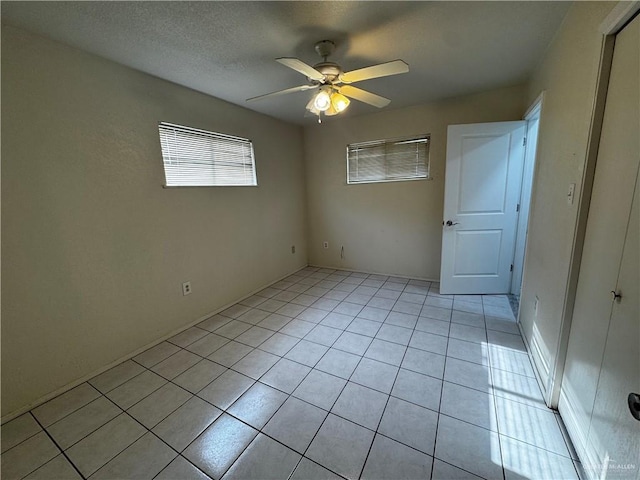 tiled spare room with ceiling fan