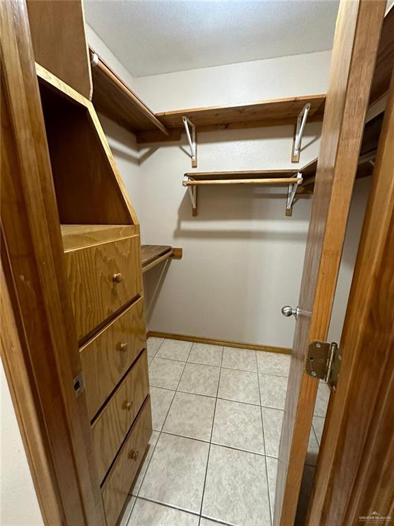 spacious closet with light tile patterned floors