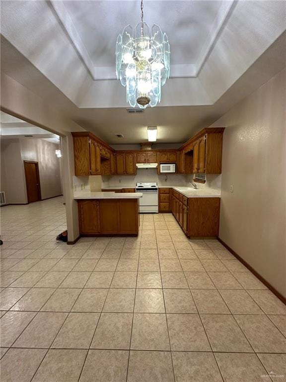 kitchen featuring white appliances, decorative light fixtures, a raised ceiling, and an inviting chandelier