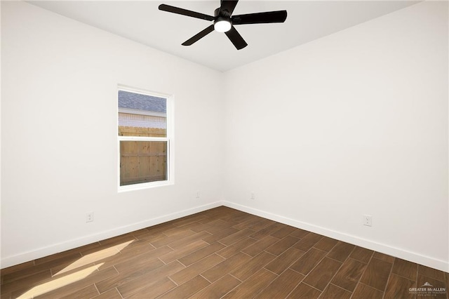 spare room with baseboards, dark wood-type flooring, and ceiling fan