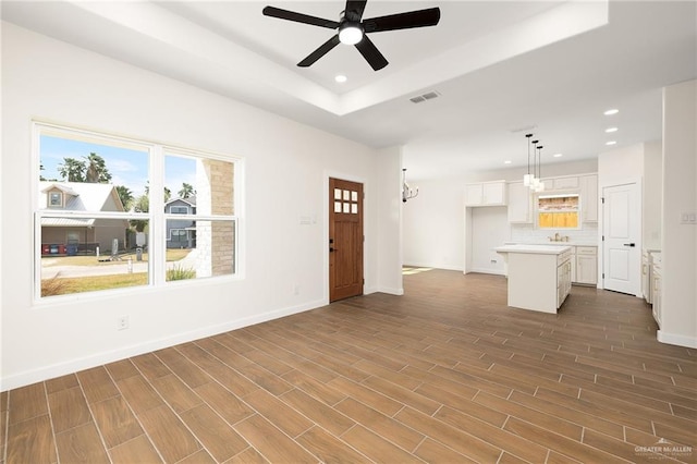 unfurnished living room featuring a ceiling fan, visible vents, dark wood-style floors, and recessed lighting