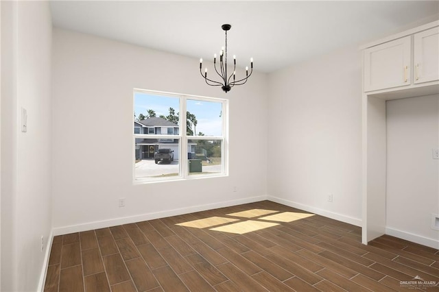 unfurnished dining area featuring baseboards, a chandelier, and dark wood-style floors