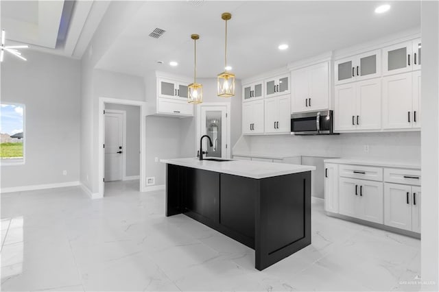 1326 S 9th St, Alamo, TX 78516 - kitchen with stainless steel microwave, a sink, light marble finish flooring, recessed lighting, and white cabinetry