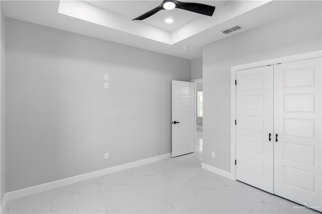 1326 S 9th St, Alamo, TX 78516 - unfurnished bedroom with baseboards, light marble finish floors, a raised ceiling, a closet, and a ceiling fan