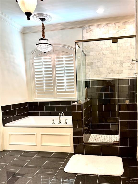 1630 E California Rd, Los Fresnos, TX 78566 - bathroom with a garden tub, a shower stall, and crown molding