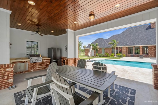 1630 E California Rd, Los Fresnos, TX 78566 - view of patio featuring exterior kitchen, outdoor dining space, an outdoor pool, and a ceiling fan