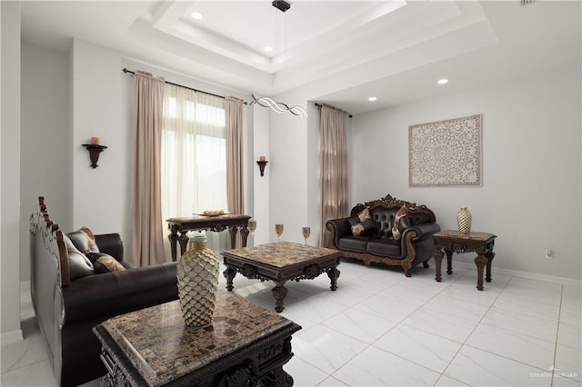 living room featuring recessed lighting, a tray ceiling, baseboards, and marble finish floor