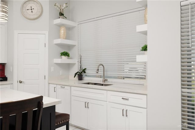 kitchen with a sink, light countertops, tasteful backsplash, and open shelves