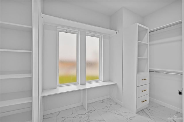 walk in closet with marble finish floor