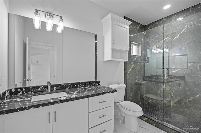 full bathroom featuring toilet, marble finish floor, a marble finish shower, and vanity