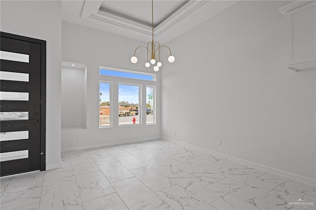 interior space with marble finish floor, a tray ceiling, an inviting chandelier, and baseboards