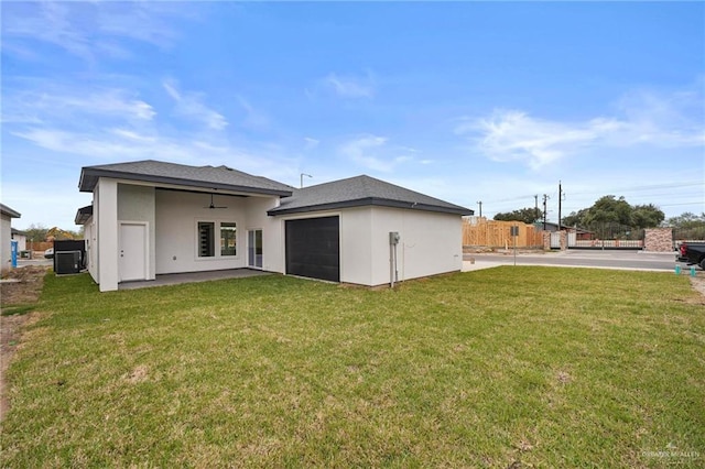 rear view of property featuring stucco siding, a yard, a patio, and ceiling fan