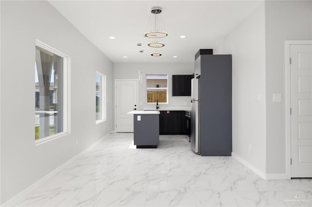 kitchen with baseboards, a center island, marble finish floor, light countertops, and recessed lighting