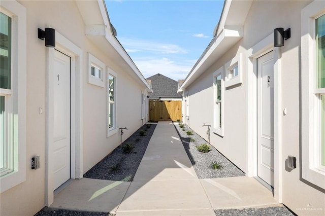 view of side of home featuring fence and stucco siding