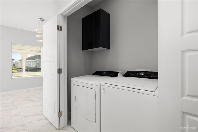 clothes washing area featuring baseboards, marble finish floor, cabinet space, and washer and dryer