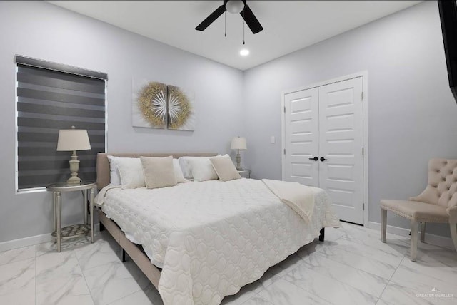 bedroom featuring marble finish floor, a closet, and baseboards