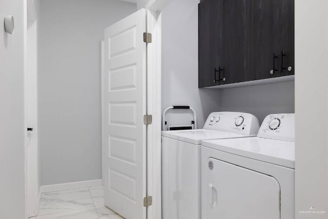 laundry area featuring cabinet space, baseboards, marble finish floor, and washing machine and clothes dryer