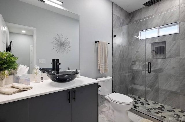 full bathroom with marble finish floor, a stall shower, vanity, and toilet