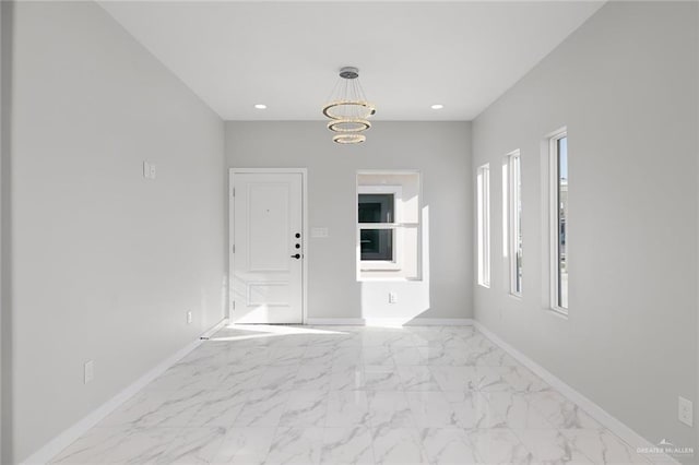 unfurnished room with recessed lighting, marble finish floor, and baseboards