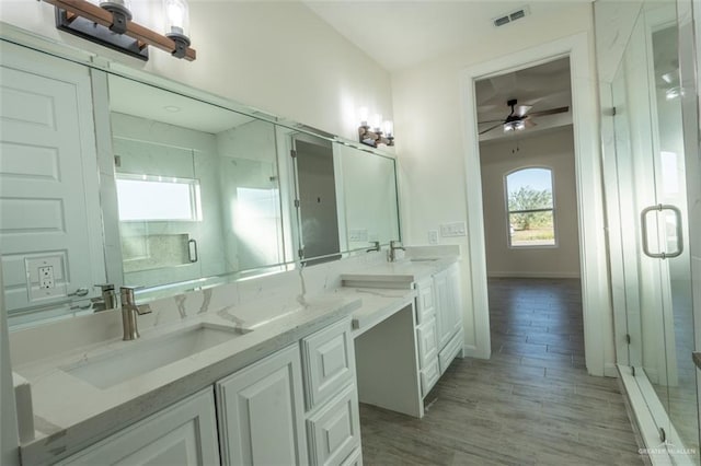 bathroom featuring walk in shower, wood-type flooring, vanity, and ceiling fan