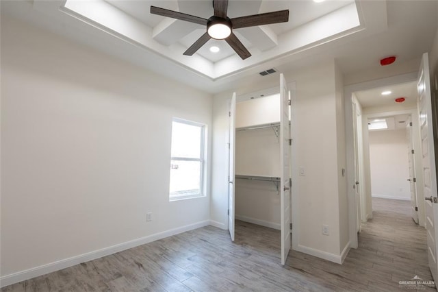 unfurnished bedroom with ceiling fan, a closet, and light hardwood / wood-style flooring