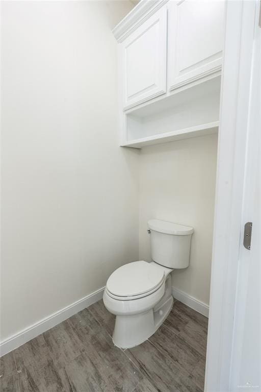 bathroom featuring toilet and wood-type flooring